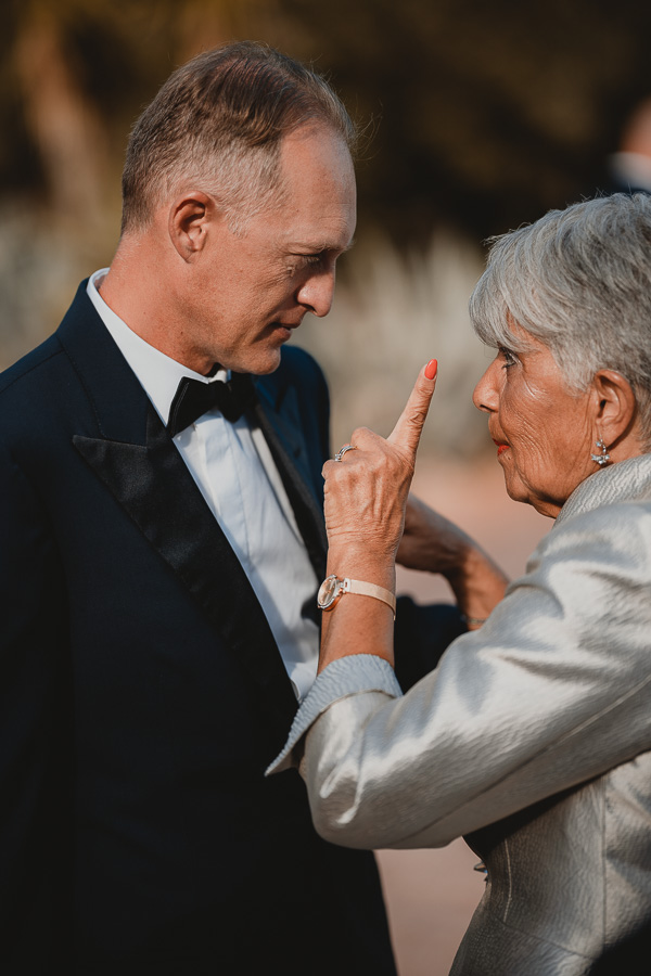 Sposo che riceve le ultime raccomandazioni dalla suocera mentre attende l'arrivo della sposa