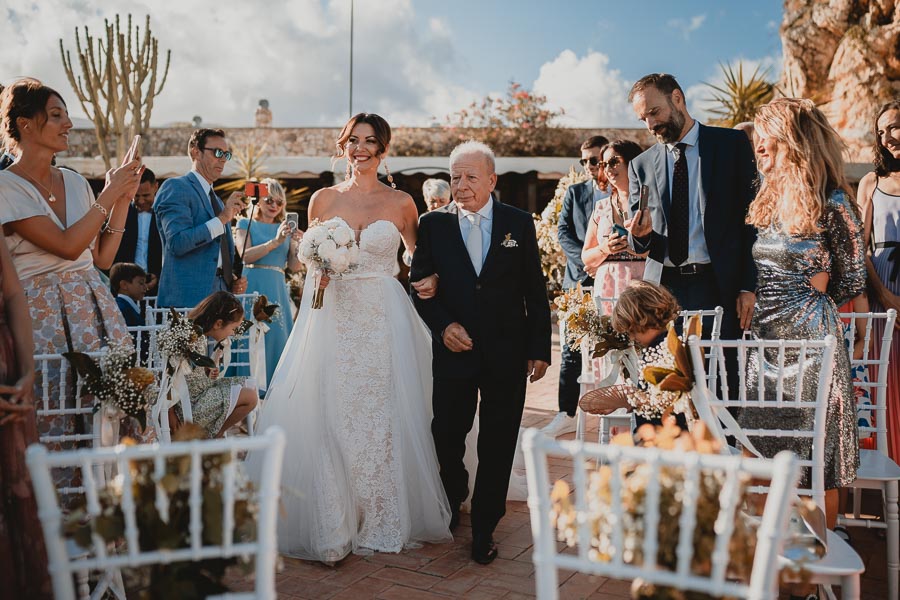 Arrivo della sposa alla cerimonia di matrimonio alla Torre di Scopello accompagnata dal padre