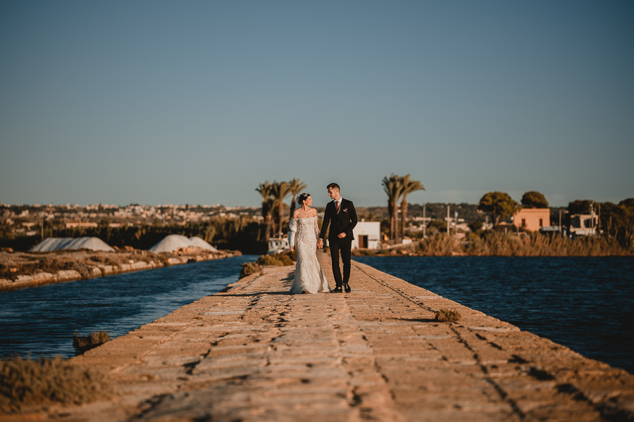 Ritratto Sposi mentre camminano ed interagiscono all'antico imbarcadero delle Saline di Marsala