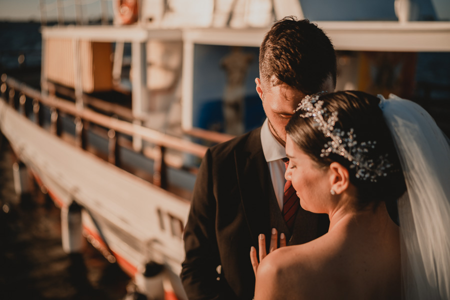 Ritratto Sposi in Primo Piano mentre si coccolano a fianco ad un'antica barca alle Saline di Marsala