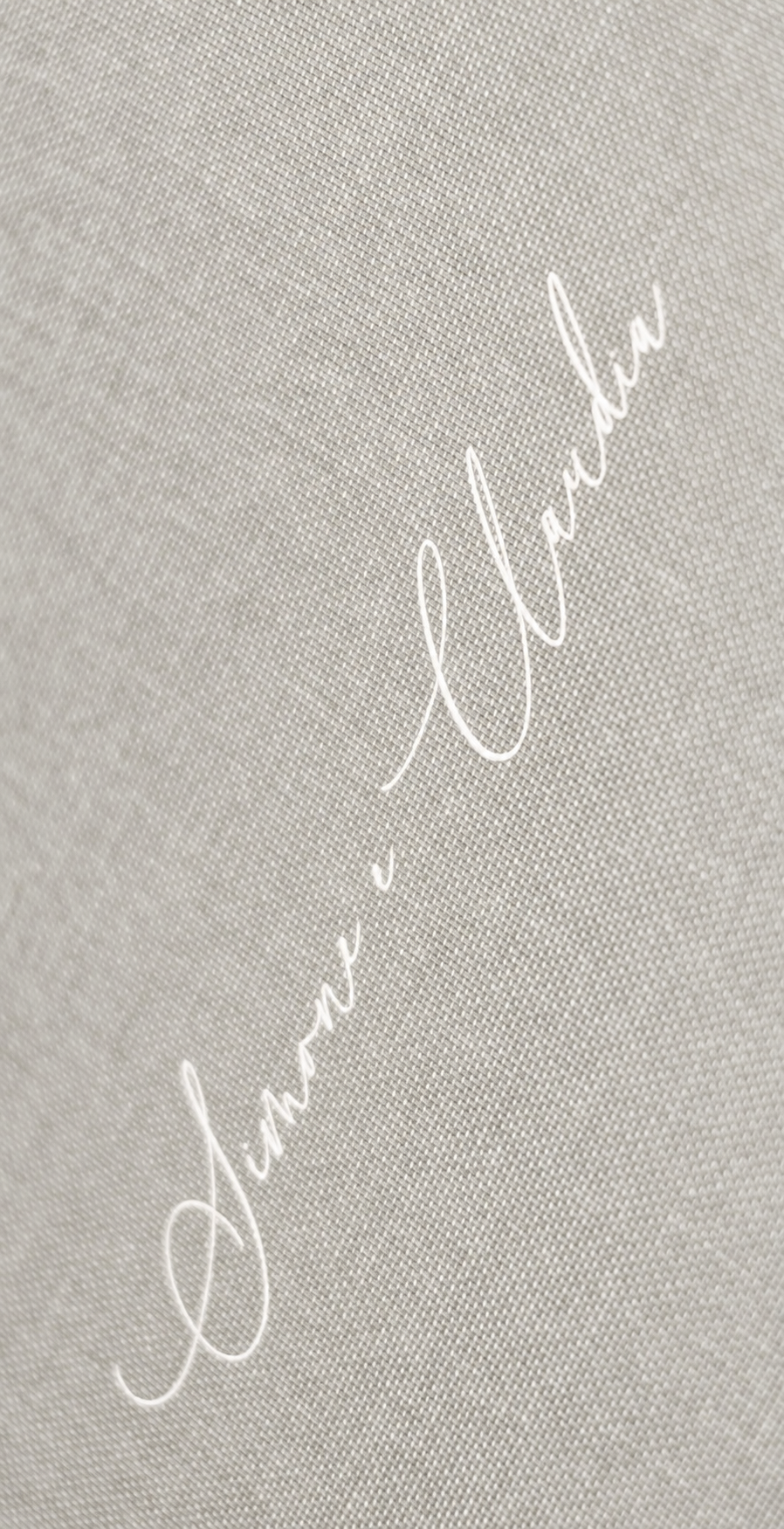 Close-up of personalised white lettering on a light linen-grey Basic album cover.